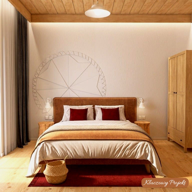 Jasna sypialnia z drewnianym sufitem, łóżkiem z bordowymi poduszkami i okrągłą dekoracją na ścianie. Szafa z jasnego drewna i lampki nocne dopełniają aranżację.