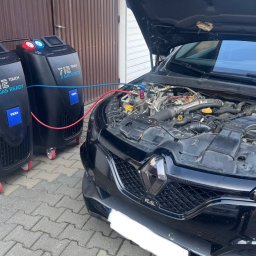 Mechanika Samochodowa SZYNALIK Damian Szynalik - Czarny samochód z otwartą maską, podłączony do dwóch urządzeń TEXA 712 Touch 2 Gas Ready, prawdopodobnie podczas serwisu klimatyzacji. Widoczne przewody i silnik.