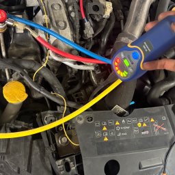 Mechanika Samochodowa SZYNALIK Damian Szynalik - Sprawdzanie szczelności klimatyzacji samochodowej w Mszanie Dolnej za pomocą detektora nieszczelności. Widoczne przewody i elementy silnika.