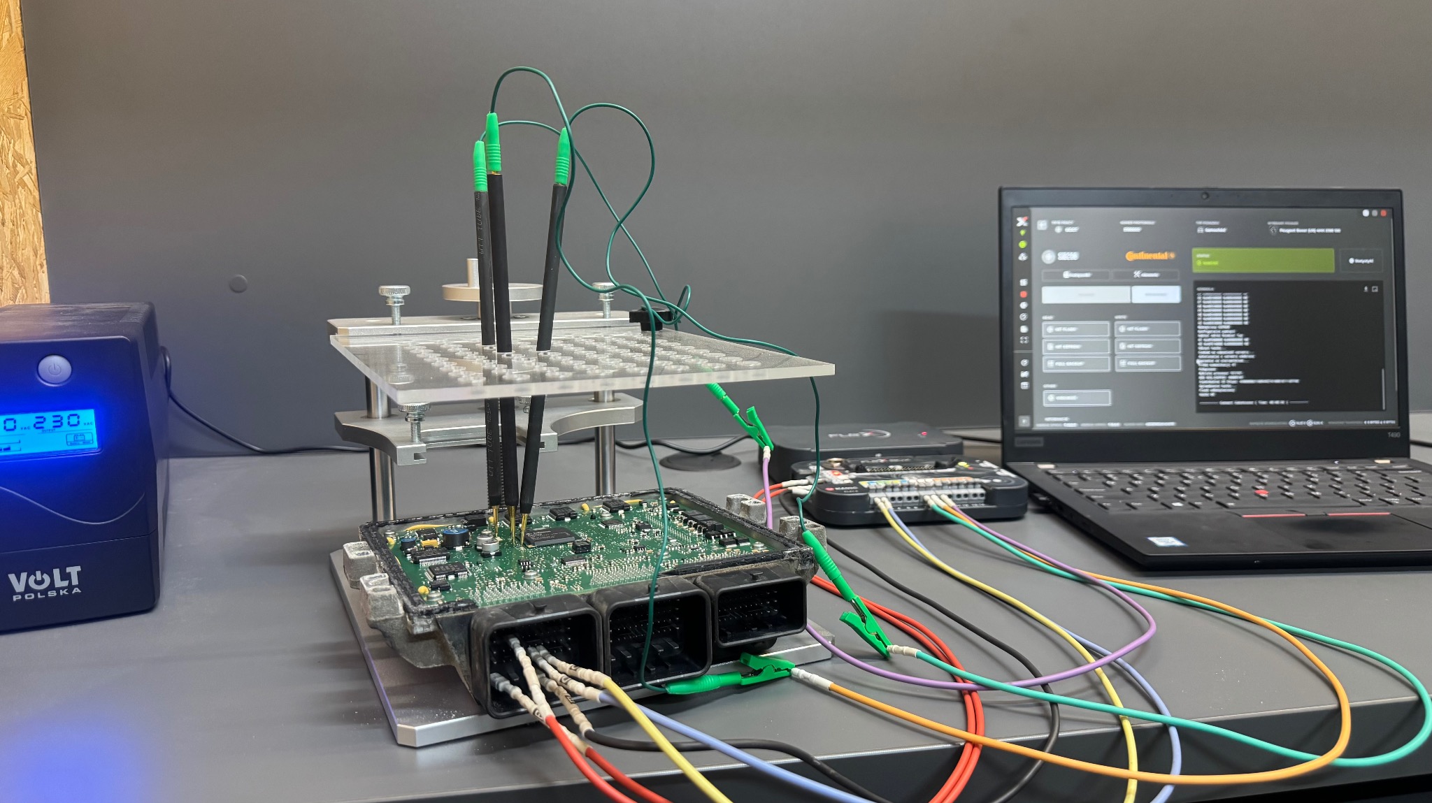 Diagnostyka sterownika silnika na stanowisku testowym: podpięty moduł, oscyloskop, laptop z oprogramowaniem diagnostycznym. Precyzyjne pomiary i analiza danych.