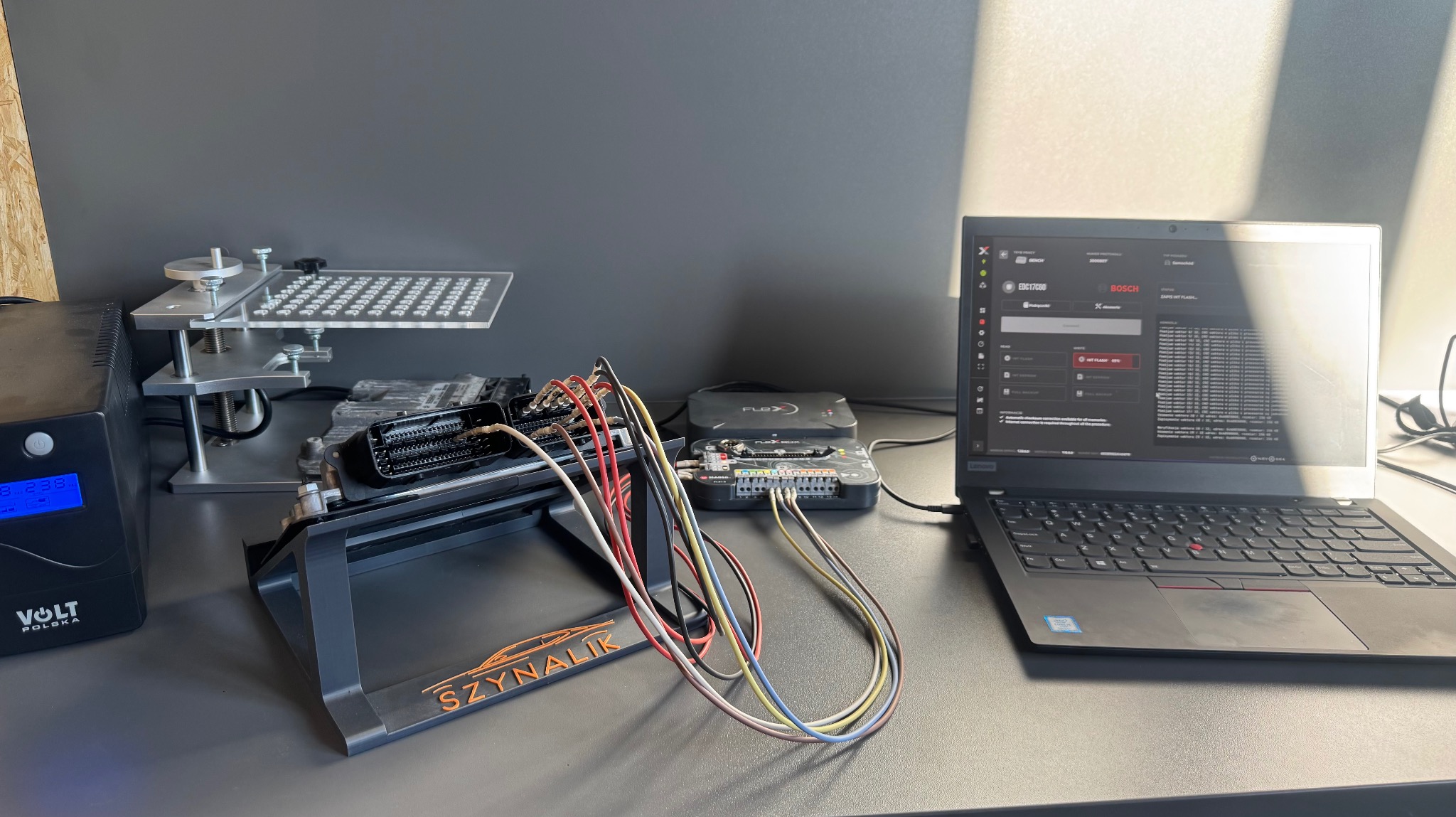 Stanowisko diagnostyczne z podłączonym sterownikiem silnika, interfejsem FLEXbox i laptopem z uruchomionym oprogramowaniem BOSCH. Widoczne kable i zasilacz VOLT Polska.