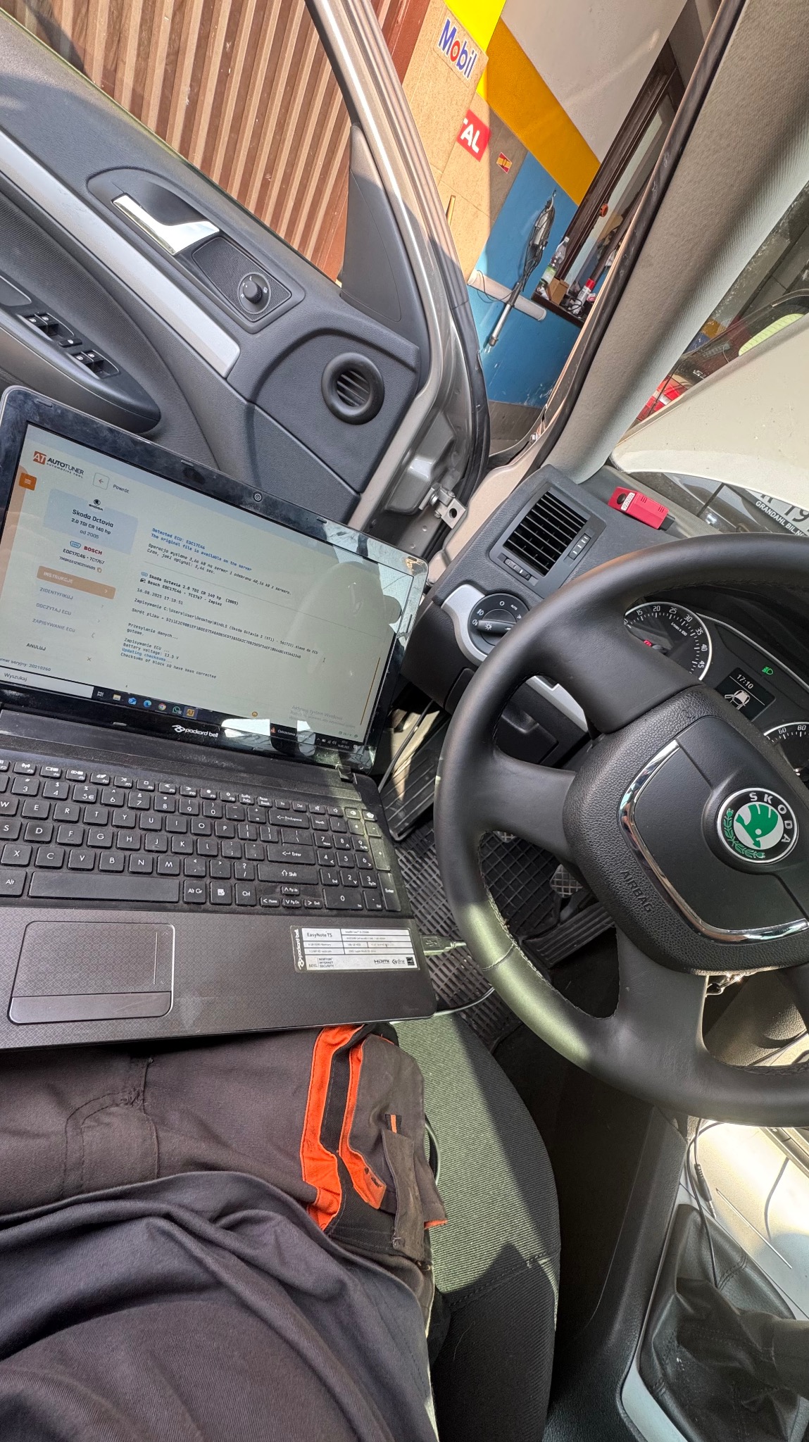 Diagnostyka komputerowa Skoda Octavia: laptop z uruchomionym programem diagnostycznym podłączony do samochodu. Widoczna deska rozdzielcza i kierownica.