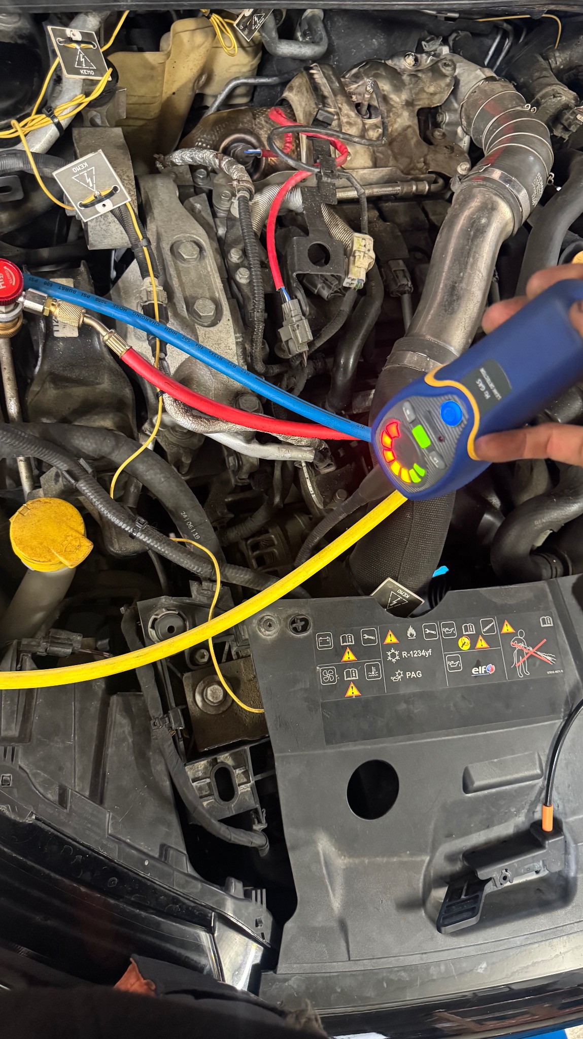 Sprawdzanie szczelności klimatyzacji samochodowej w Mszanie Dolnej za pomocą detektora nieszczelności. Widoczne przewody i elementy silnika.