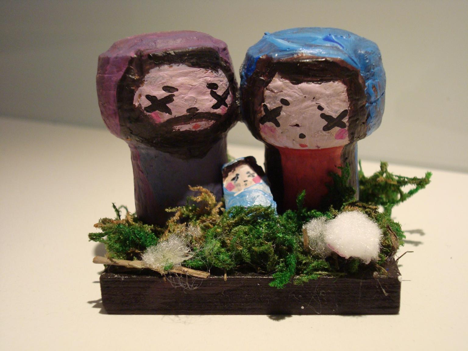 Ręcznie robiona szopka bożonarodzeniowa z drewnianych figurek na podstawie z mchu i patyczków.