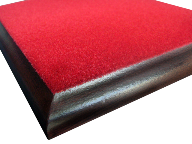 Czerwony flok na drewnianej podstawie z zaokrąglonymi krawędziami, wykonany przez firmę z Wołomina.