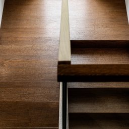 STARMACH STUDIO KAROLINA SMOTER-STARMACH - Drewniane schody z oświetleniem górnym, minimalistyczna balustrada. Nowoczesne wykończenie wnętrza z dbałością o detale i naturalne światło.