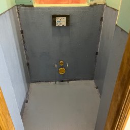 Mirosław Grzybek Wykończenia z Pasją - Przygotowanie do hydroizolacji w łazience w Skoczowie. Widoczne zabezpieczone ściany i podłoga, gotowe do dalszych prac wykończeniowych. Detal: taśma uszczelniająca.