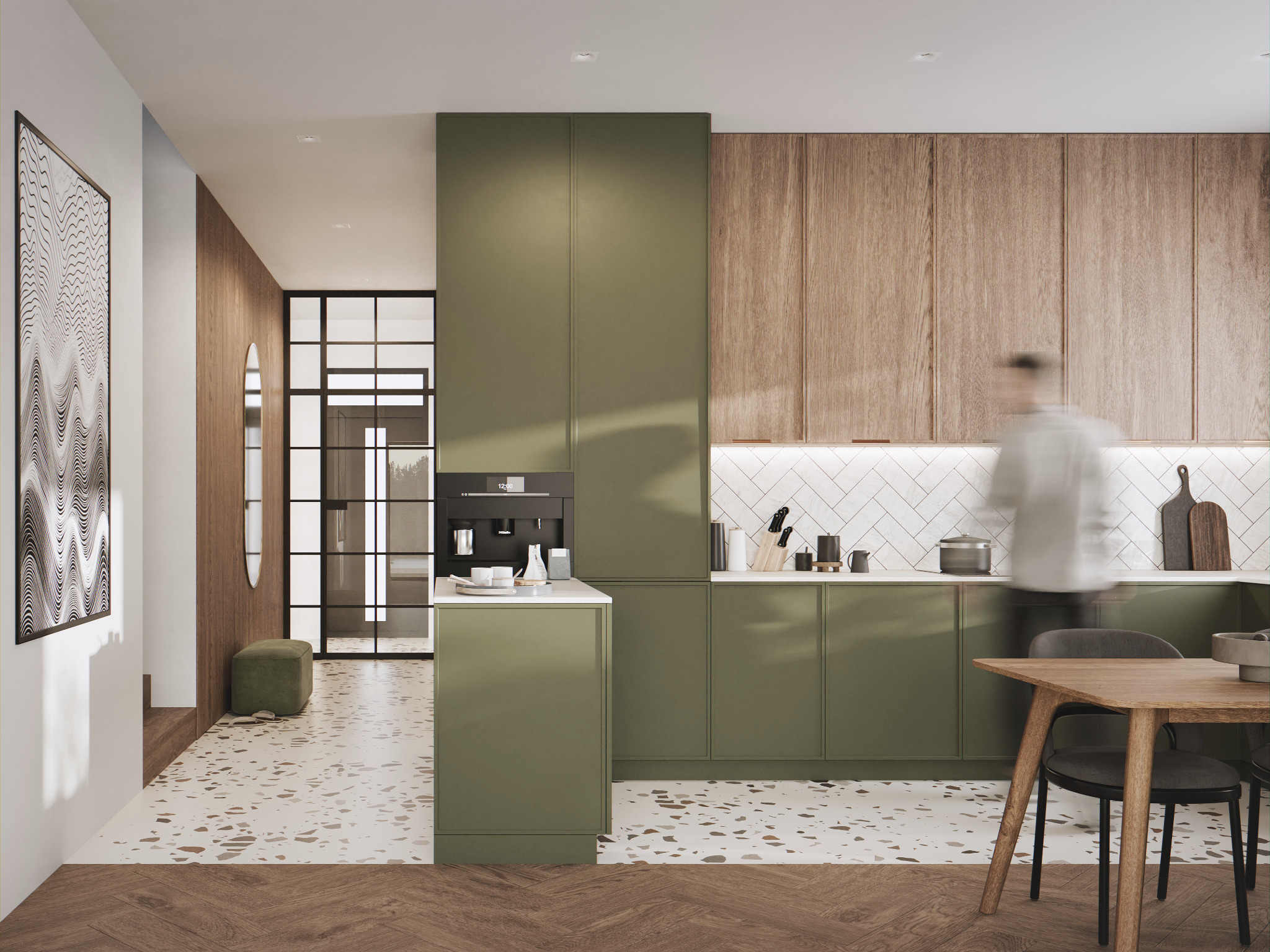 Nowoczesna kuchnia w odcieniach zieleni i drewna z białymi płytkami chevron, drewnianym stołem i krzesłami. W tle widoczny korytarz z lustrem i pufą.