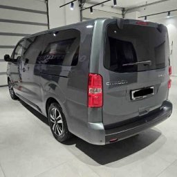 Lobo - Szary bus Citroen SpaceTourer, widok z tyłu, zaparkowany w jasnym pomieszczeniu z bramą garażową. Widoczne detale: felgi, światła, logo Citroen.