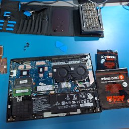 KL3DS Krystian Łukowicz - Otwarty laptop z widoczną płytą główną, obok narzędzia, śrubokręty, pasta termoprzewodząca i podkładki termiczne. Widok z góry na stanowisko pracy serwisanta komputerowego.