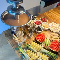 PIOTR NOWAK & CO. EVENTS - Stół z fontanną czekoladową otoczoną owocami: ananas, arbuz, truskawki, maliny, jeżyny, winogrona, pianki i wafle. Idealne na słodki stół podczas imprezy.