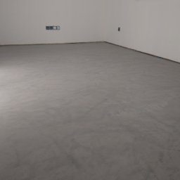 Petro Tychkovskyi - Szara, gładka posadzka mikrocementowa w jasnym pomieszczeniu z białymi ścianami i widocznymi gniazdkami elektrycznymi. Minimalistyczny design.