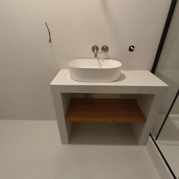 Petro Tychkovskyi - Nowoczesna łazienka z białą umywalką nablatową i drewnianą półką. Minimalistyczny design, jasne wnętrze, widoczne elementy instalacji.