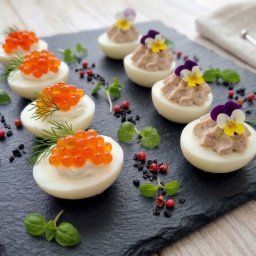 HADAM SPÓŁKA Z OGRANICZONĄ ODPOWIEDZIALNOŚCIĄ - Eleganckie jajka faszerowane z kawiorem i pastą, udekorowane kwiatami, na czarnym kamieniu. Wykwintne przekąski z Warszawy, idealne na przyjęcie.