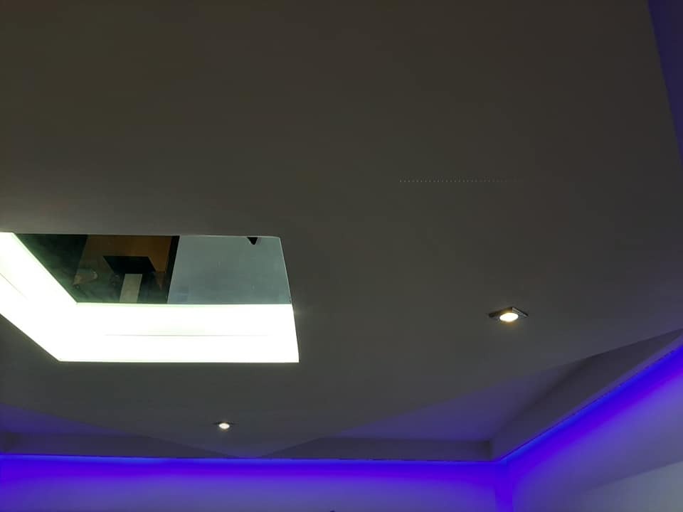 Podwieszany sufit z oświetleniem LED: kwadratowa lampa sufitowa i niebieskie światło obwodowe. Nowoczesny design, subtelne oświetlenie punktowe.