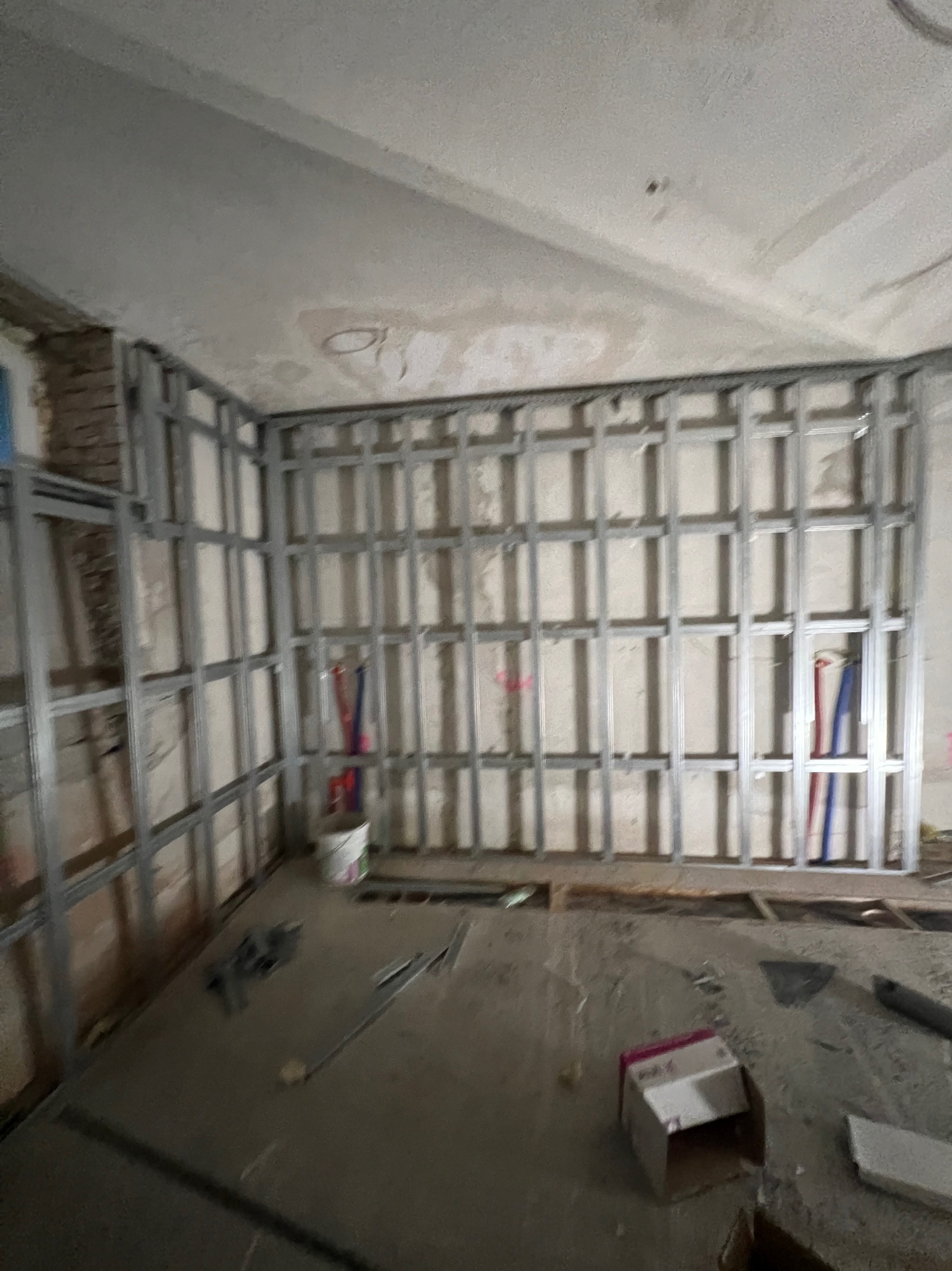 Metalowa konstrukcja ścian działowych z profili, widoczne instalacje, surowy stan, przygotowanie do montażu płyt gipsowo-kartonowych w trakcie remontu.