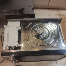 GTX SERVICE SP. Z O.O. SPÓŁKA KOMANDYTOWA - Wnętrze piekarnika Bosch z widocznym elementem grzejnym i modułem sterującym, ukazujące etap naprawy lub konserwacji. Widoczne przewody i elementy mocujące.