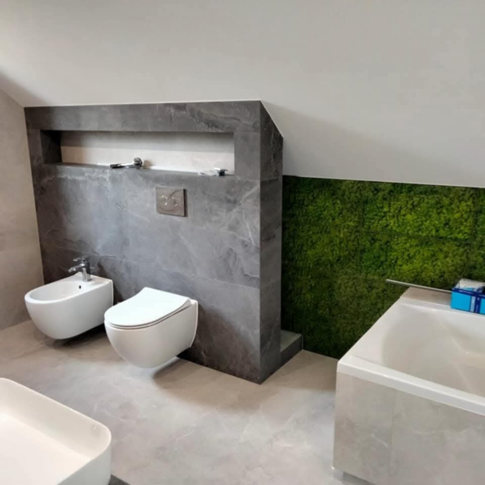 Nowoczesna łazienka na poddaszu z szarą ścianą z marmuru, toaletą, bidetem i panelem z mchu. Minimalistyczny design z akcentem natury.