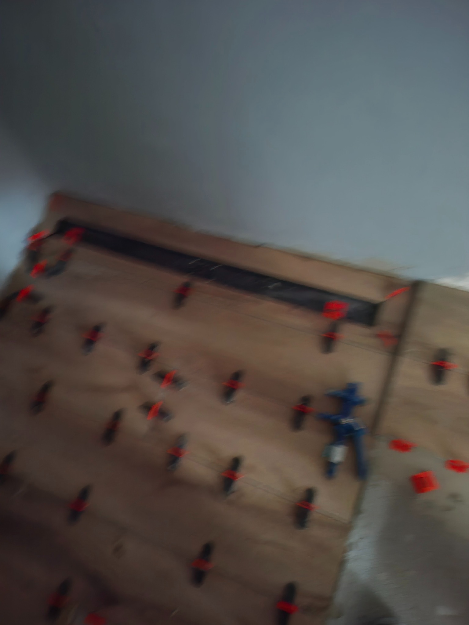 Ściana z płyt kartonowo-gipsowych, z widocznymi elementami mocującymi i narzędziem do montażu, w trakcie prac wykończeniowych. Ujęcie z bliska, z góry.