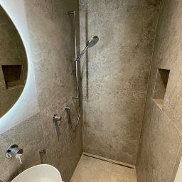 TIP-TOP GLAZURNIK Marcin Kapuściński - Beżowa łazienka z owalną umywalką, chromowaną armaturą i kabiną prysznicową typu walk-in. W ścianie wnęka. Minimalistyczny design, neutralna kolorystyka.