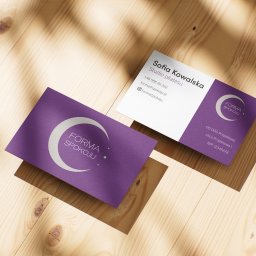 Karol Maryniak - Dwie wizytówki w odcieniach fioletu i bieli z logo 'Forma Spokoju' leżą na drewnianym stole w ciepłym świetle. Minimalistyczny design, czcionka bezszeryfowa.