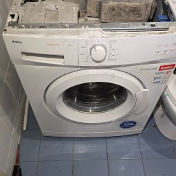 Mobilny Serwis AGD MSA - Adrian Bańdo - Otwarta pralka Amica AWB510L w trakcie naprawy, widoczne wnętrze z obciążnikami i elementami elektroniki. Na podłodze leżą narzędzia.