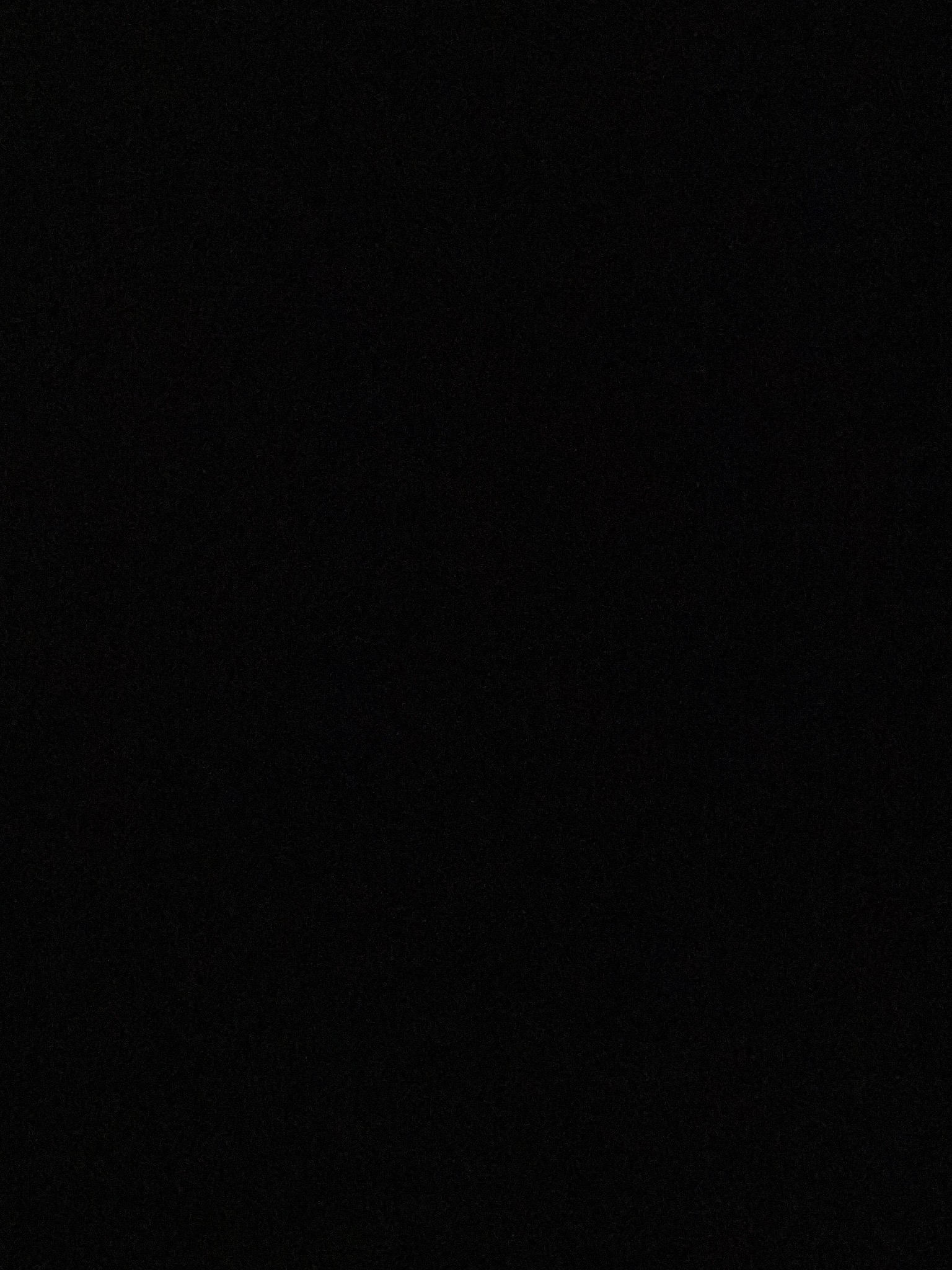 Ciemne zdjęcie, prawdopodobnie przedstawiające wnętrze szafy lub schowka, z bardzo słabym oświetleniem. Trudno dostrzec szczegóły.