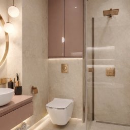 PRZEMYSŁAW RUCIŃSKI PERFEKT INTERIORS - Elegancka łazienka w beżach i różu: okrągłe lustro z podświetleniem, wisząca toaleta, kabina prysznicowa ze złotą armaturą i szafka nad nią. Nowoczesny design.