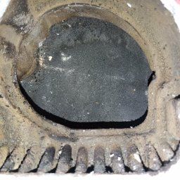 WOJ-TECH Wojciech Świderski - Zanieczyszczony palnik gazowy z widocznymi śladami korozji i nagaru, ukazujący zużycie elementu pieca gazowego. Detal z bliska.