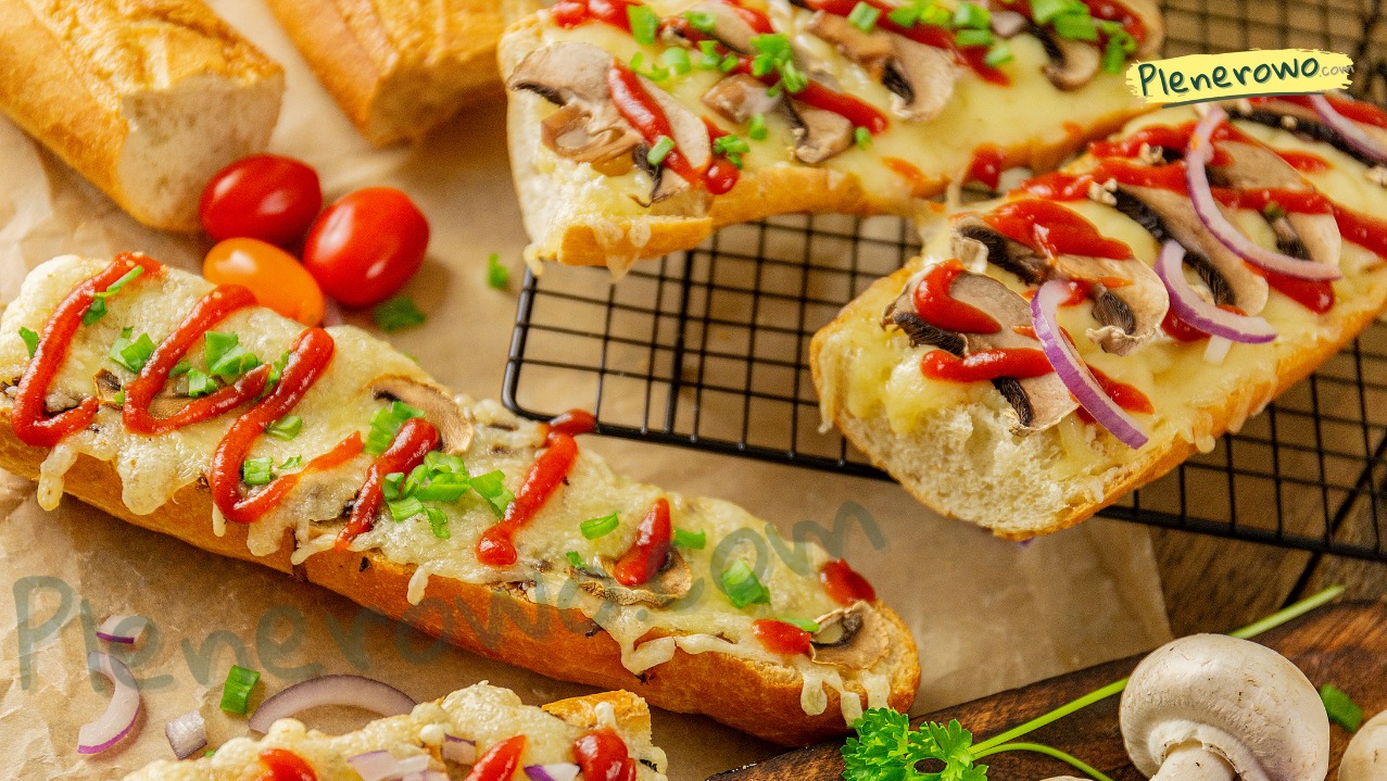 Zapiekanki na bagietce z pieczarkami, serem, czerwoną cebulą i sosem, ułożone na papierze i kratce, z dodatkiem pomidorów i pieczarek obok. Przygotowane do wypożyczenia.