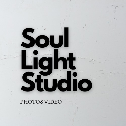 Minimalistyczne logo Soul Light Studio na tle białej, teksturowanej ściany. Czarny, pogrubiony font i dopisek 'PHOTO&VIDEO' poniżej.