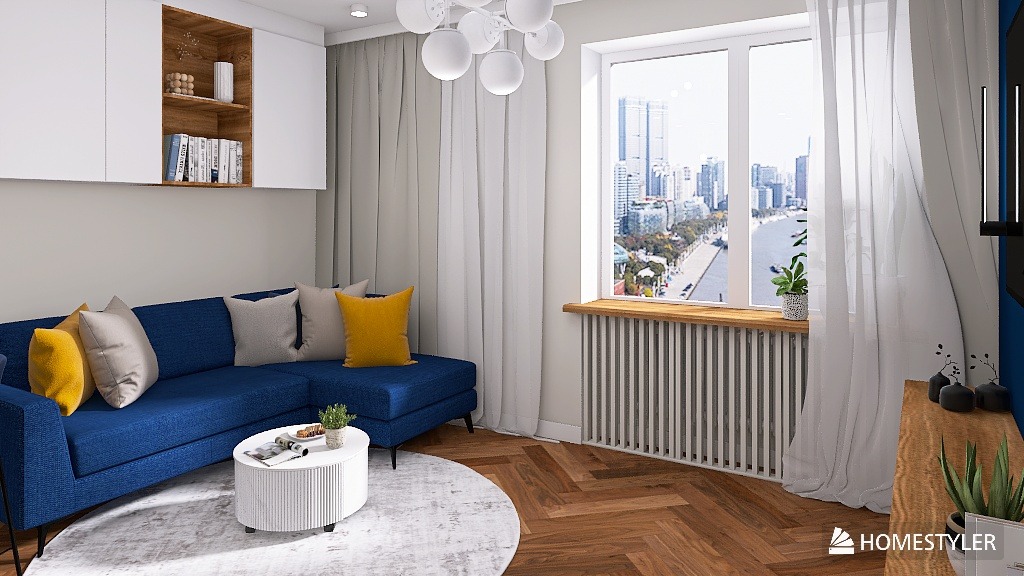 Stylowy salon z niebieską sofą narożną, okrągłym stolikiem kawowym i parkietem w jodełkę. Za oknem widok na miasto. Nad sofą białe szafki i półki z dekoracjami.