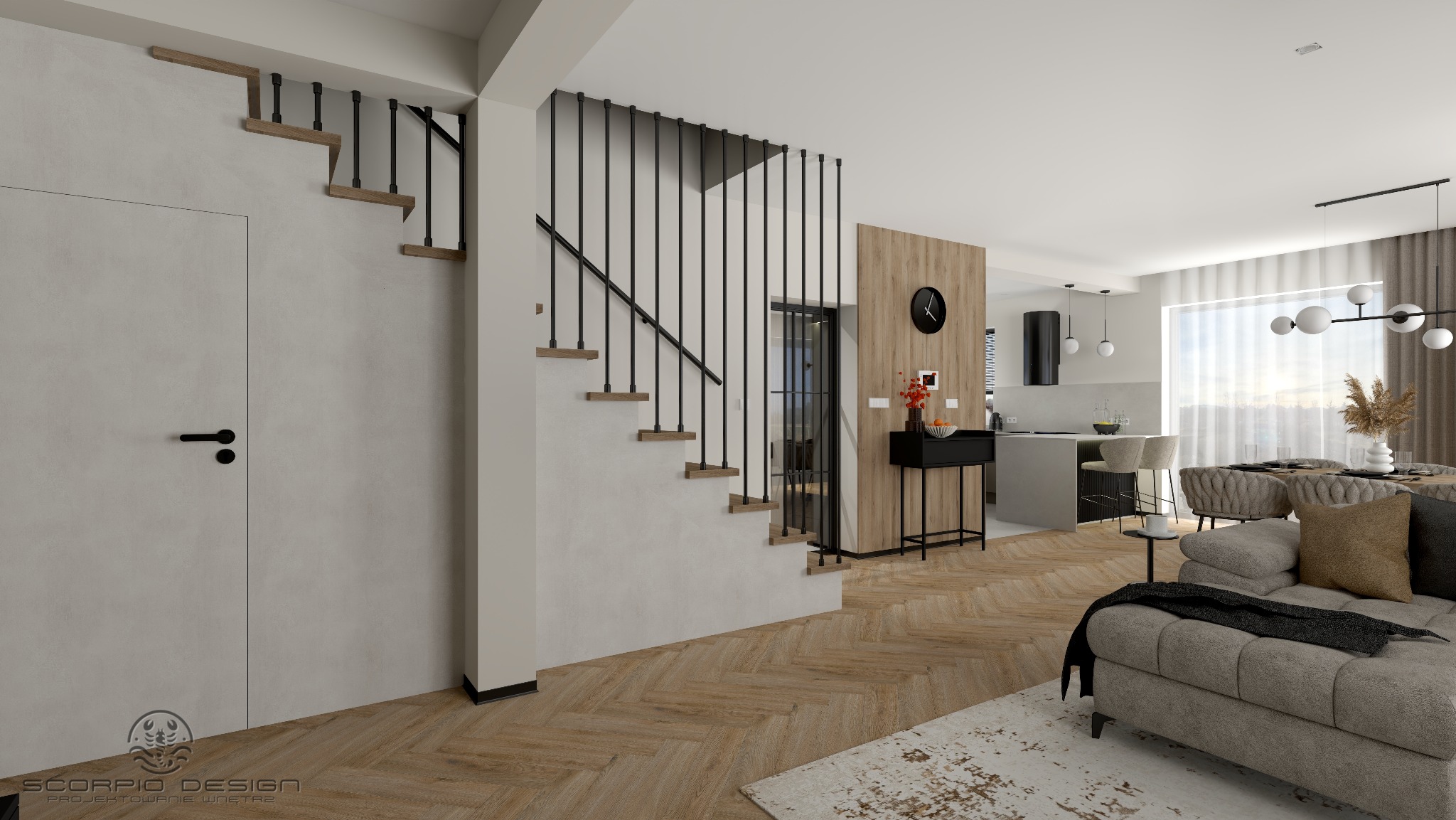 Wnętrze domu z otwartą przestrzenią: schody z czarną balustradą, parkiet w jodełkę, szara sofa i widok na kuchnię z wyspą. Nowoczesny design z elementami drewna.