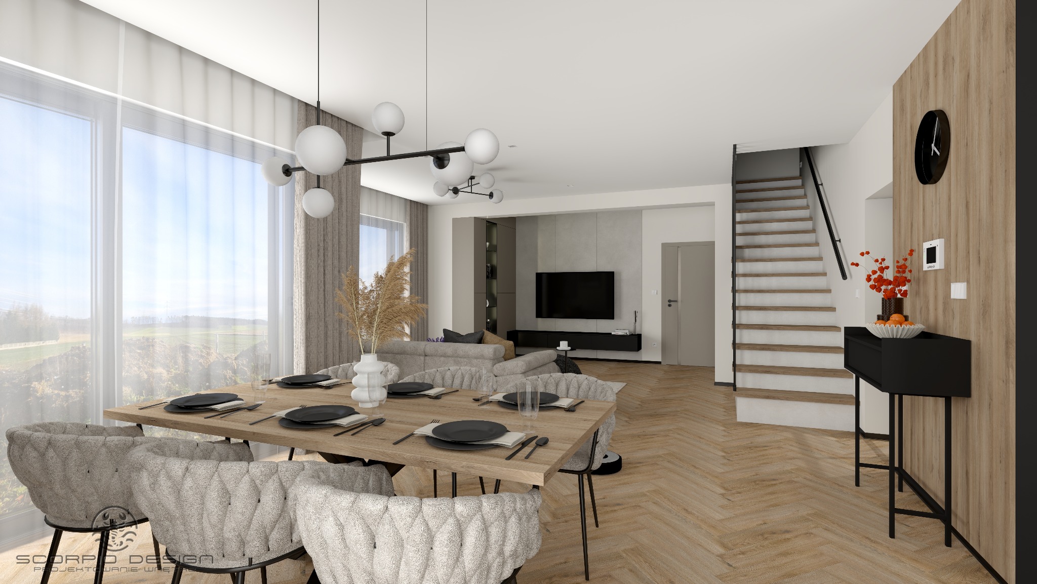 Wnętrze domu: jadalnia z drewnianym stołem i krzesłami w stylu skandynawskim, salon z telewizorem, schody. Parkiet w jodełkę, duże okno z widokiem na zieleń.