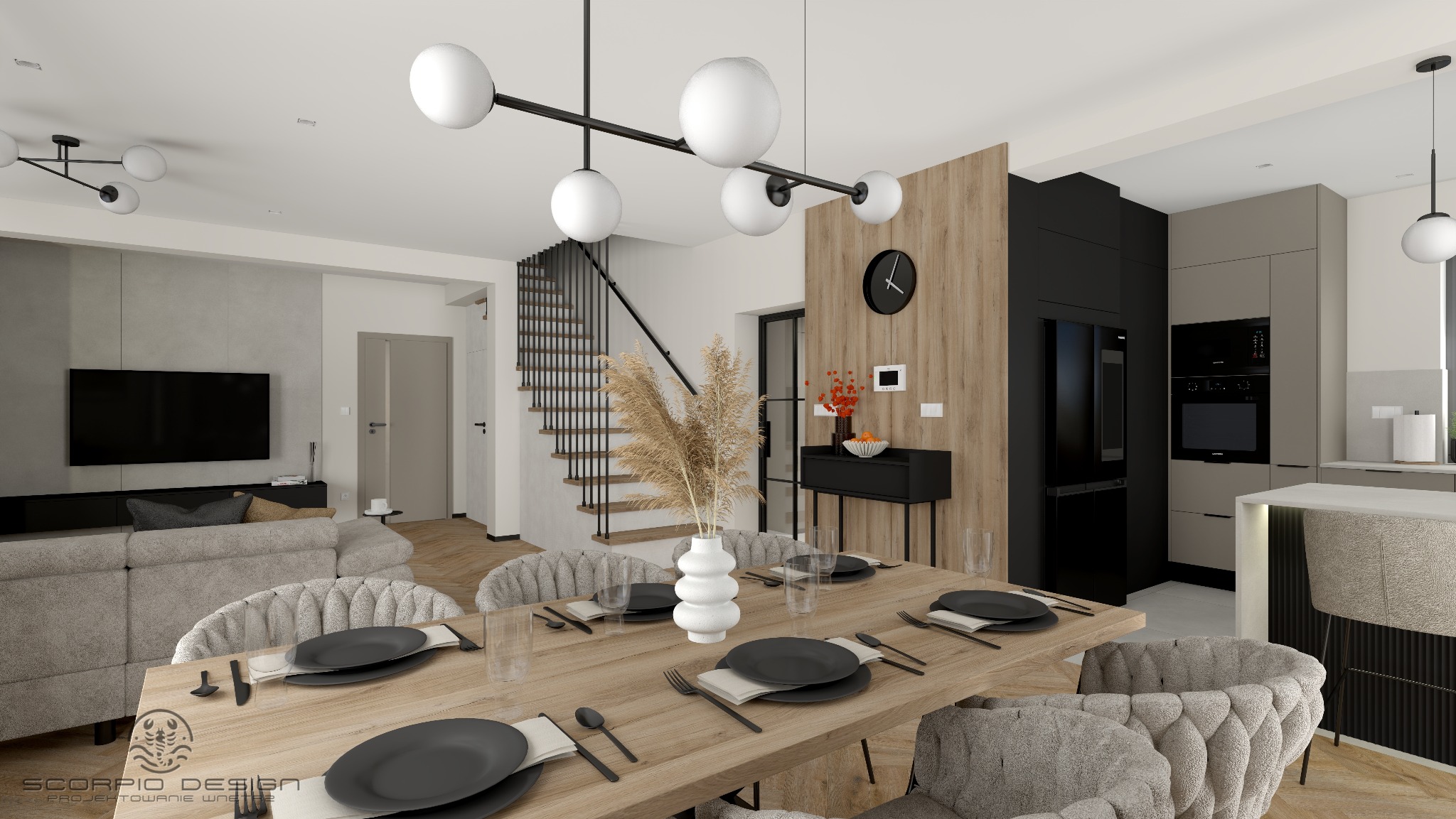 Wnętrze domu z otwartą kuchnią i jadalnią. Stół z nakryciami, krzesła z tapicerką, schody z czarną balustradą, nowoczesne oświetlenie i zabudowa kuchenna.