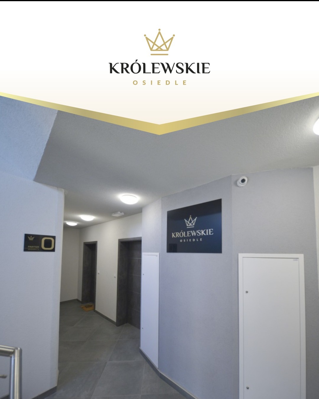Korytarz w nowym osiedlu z oznaczeniami 'Parter' i logo 'Królewskie Osiedle' na ścianie. Szare płytki podłogowe, białe ściany i drzwi do mieszkań.
