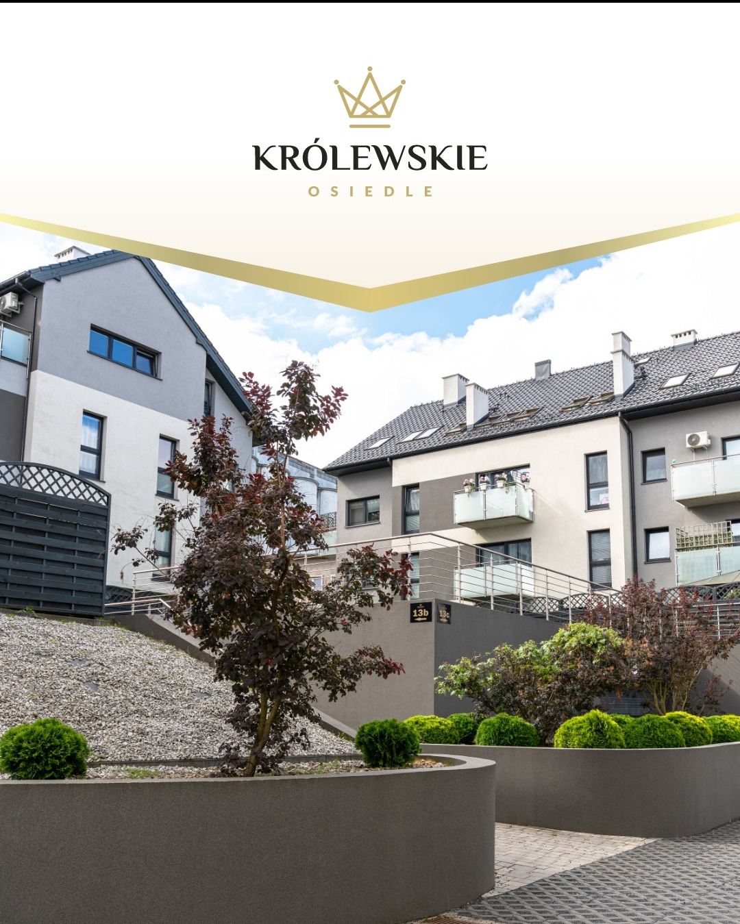 Nowoczesne osiedle Królewskie z niską zabudową, szarymi elewacjami i balkonami, otoczone zielenią i kamiennymi skarpami. Widok na budynki z poziomu chodnika.