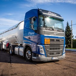 Barter S.A. - Ciężarówka cysterna firmy Barter w niebiesko-białych barwach, zaparkowana na betonowym placu, z widoczną tablicą ostrzegawczą i logotypem firmy.