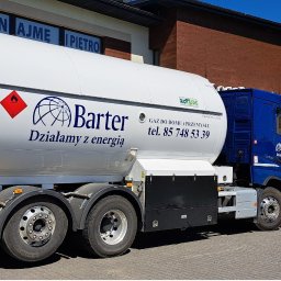 Barter S.A. - Cysterna z logo firmy Barter, dostarczająca gaz do domów i przemysłu, zaparkowana na brukowanym placu w słoneczny dzień. Widoczny budynek w tle.