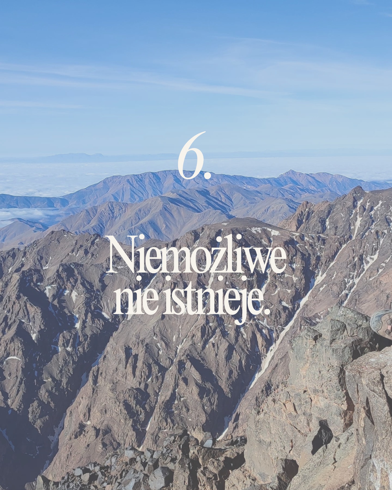 Inspirujący widok górski z tekstem 'Niemożliwe nie istnieje' w Warszawie. Motywacja i determinacja w dążeniu do celów, nawet w trudnym terenie.