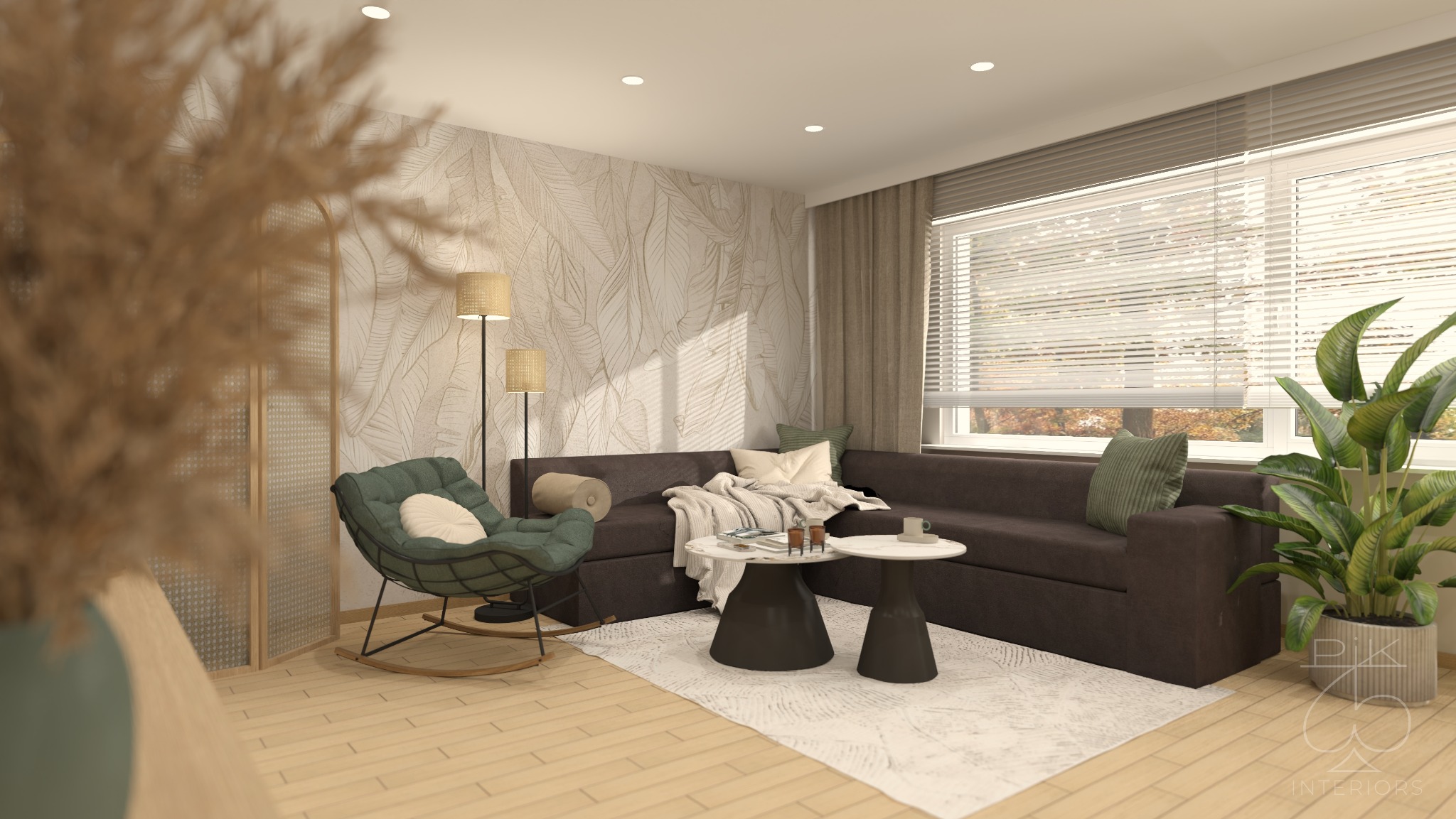 Salon w neutralnych barwach z akcentami zieleni: sofa narożna, fotel bujany, stoliki kawowe, roślina doniczkowa i tapeta w liście. Przytulne wnętrze.