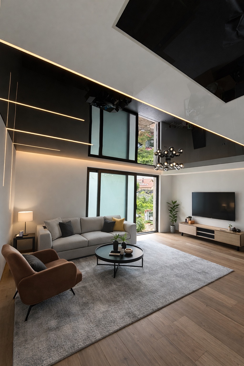 Nowoczesny salon z czarnym, lustrzanym sufitem napinanym i oświetleniem LED. Widoczny szary dywan, sofa i fotel. Duże okno z widokiem na zieleń.