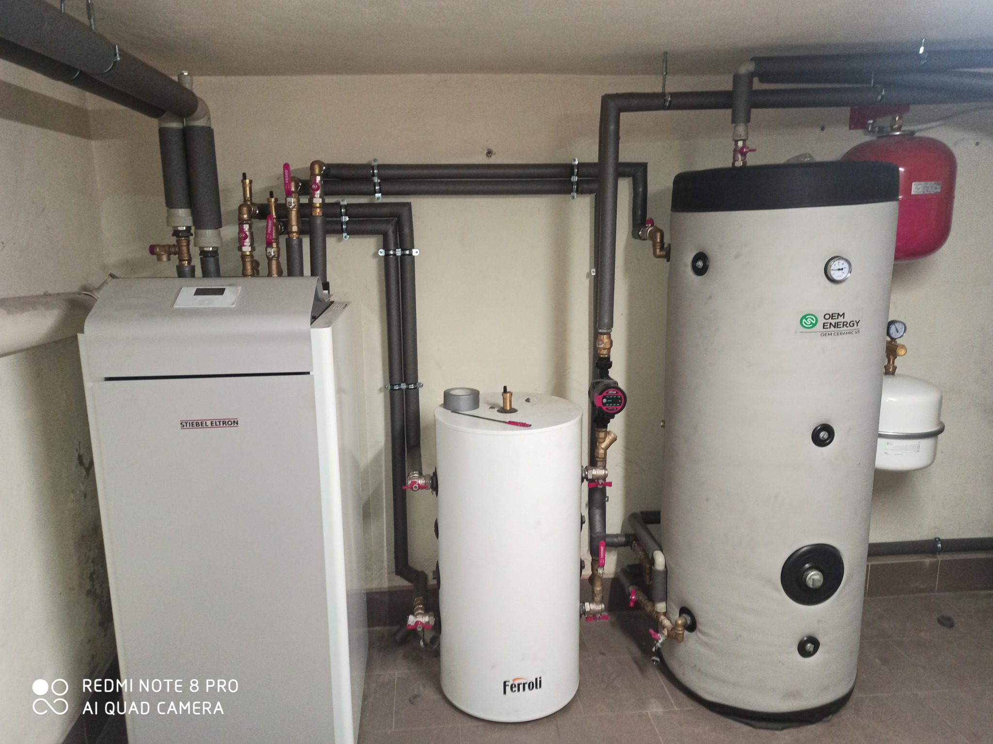 Kompletna instalacja grzewcza w Lipowej: piec Stiebel Eltron, zbiorniki Ferroli i OEM Energy, rury z izolacją. Widoczne zawory i manometry. Profesjonalny montaż.