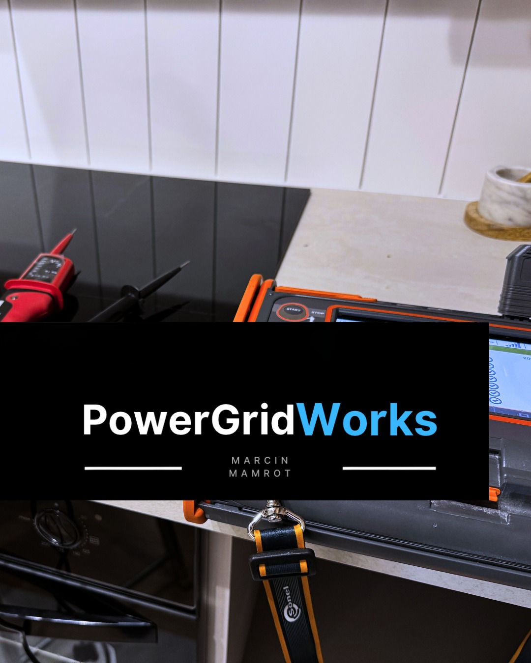 Miernik elektryczny Sonel na blacie kuchennym obok płyty indukcyjnej, gotowy do pomiarów. Widoczny przewód pomiarowy i fragment piekarnika.