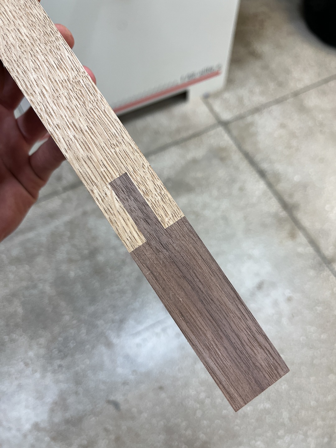 Precyzyjne połączenie dwóch rodzajów drewna, tworzące estetyczne i trwałe złącze stolarskie. Widoczne detale usłojenia i staranne wykonanie.