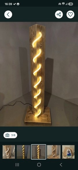 Drewniana lampa podłogowa z wbudowanym spiralnym oświetleniem LED, stojąca na drewnianej podstawie. Widoczne naturalne usłojenie drewna i ciepłe światło.