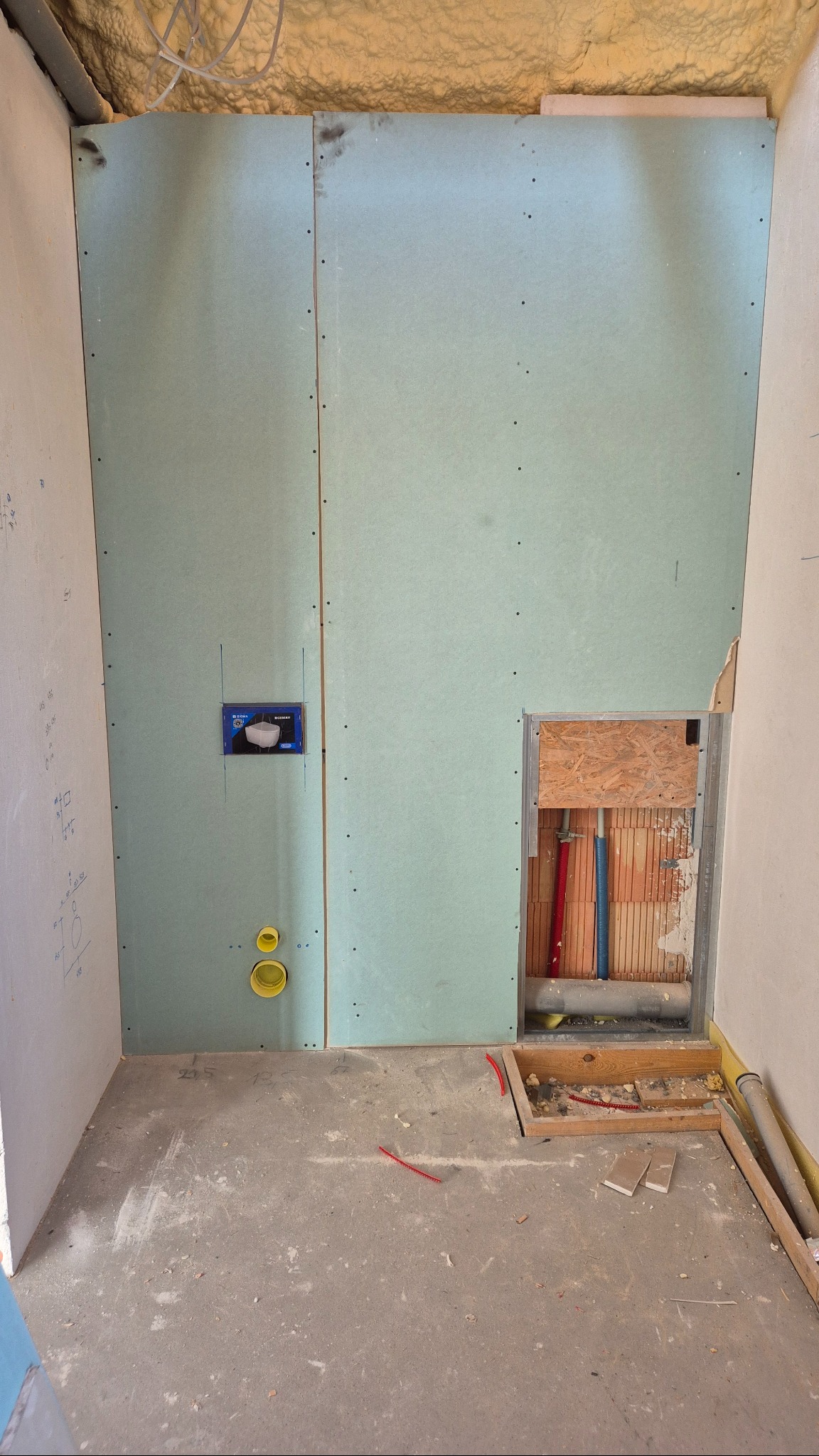 Montaż płyty GK w łazience: widoczne profile, instalacja podtynkowa WC, fragment instalacji wodnej. Surowy stan, przygotowanie do dalszych prac wykończeniowych.