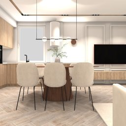 Jasne wnętrze z drewnianą zabudową kuchenną, stołem jadalnym i telewizorem. Parkiet ułożony w jodełkę. Minimalistyczne oświetlenie i dekoracje.