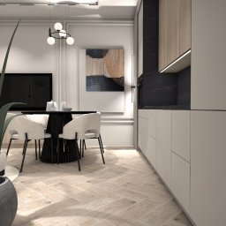 Koddo design - Eleganckie wnętrze: jadalnia z okrągłym stołem i krzesłami, parkiet w jodełkę, minimalistyczna kuchnia z drewnianymi akcentami i abstrakcyjny obraz na ścianie.