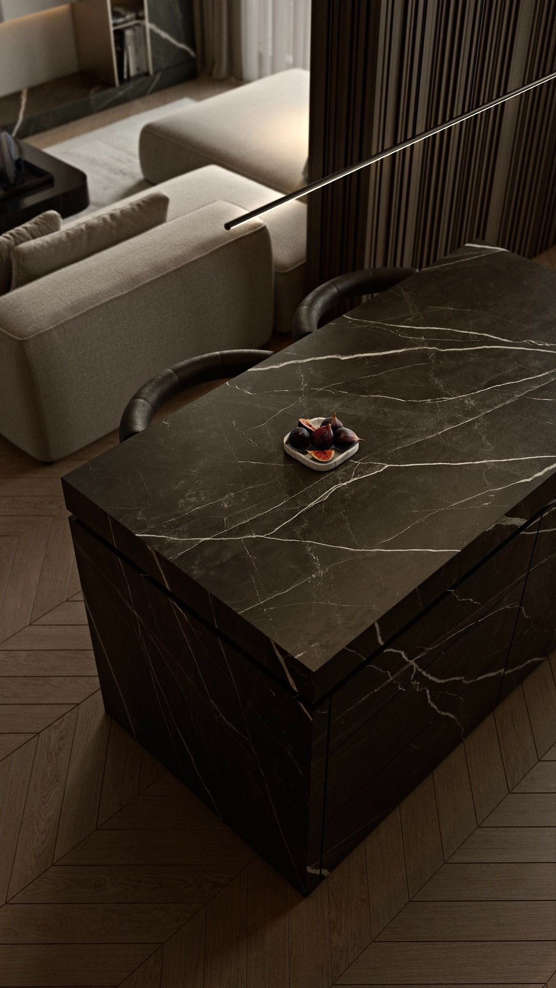 Nowoczesna wyspa kuchenna z blatem z czarnego marmuru, na której leżą figi. W tle minimalistyczny salon z sofą i drewnianą ścianą. Ciepłe oświetlenie.